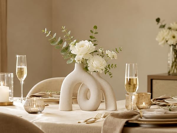 Cream ceramic donut vase with white flowers on a romantic anniversary table.