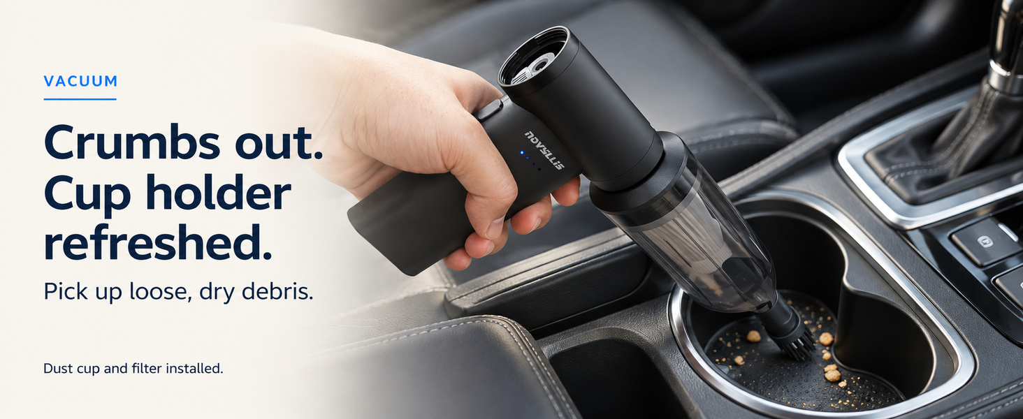 Mini car vacuum with brush nozzle picking up loose dry crumbs from a cup holder