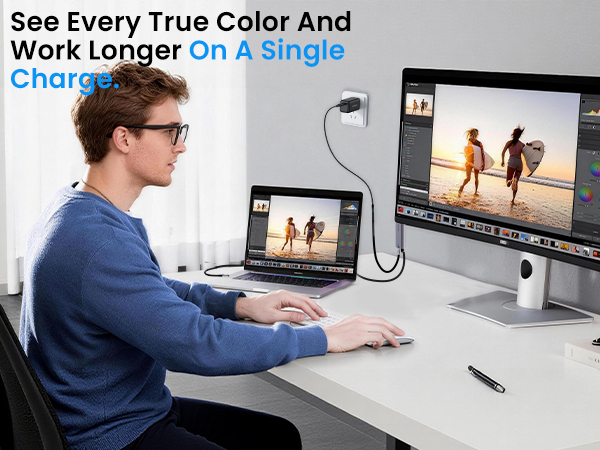 A video editor uses a SOLLPEL cable for 8K on a large screen while his laptop charges.