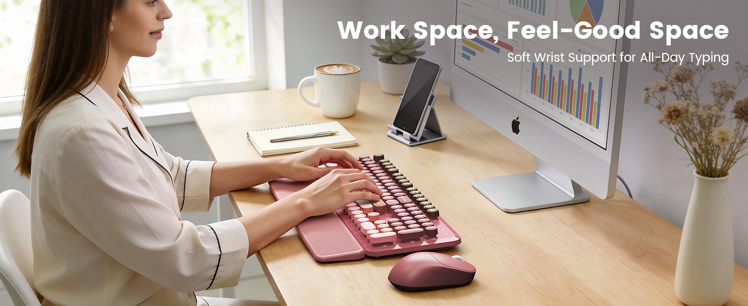 Woman typing on pink wireless keyboard mouse combo with wrist rest on tidy desk