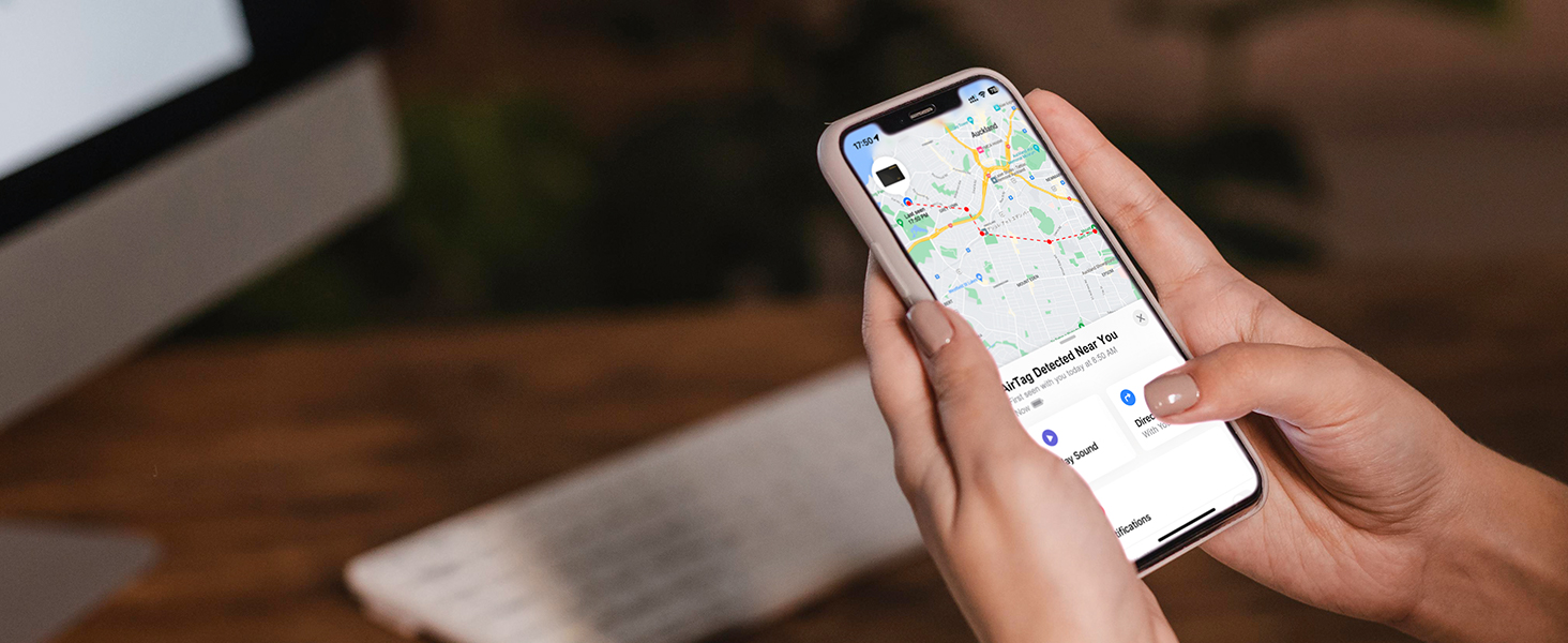 Hands holding a smartphone displaying a map application with navigation and route information on the screen.