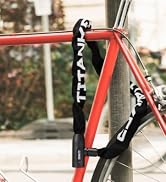 Black bike lock with white text wrapped around a red bicycle frame, securing it to a metal post. The lock appears flexible and durable.