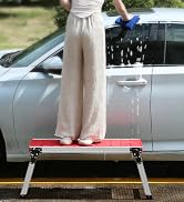 a woman standing on a platform next to a car.
