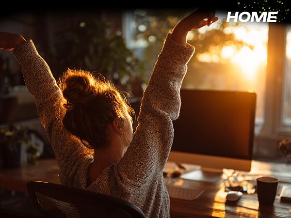 Woman stretching comfortably at home office desk after using ergonomic mouse pad wrist rest