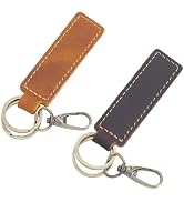 Two leather keychain fobs with stitched edges - one in tan brown, one in dark gray. Both feature metal clasps and rings.
