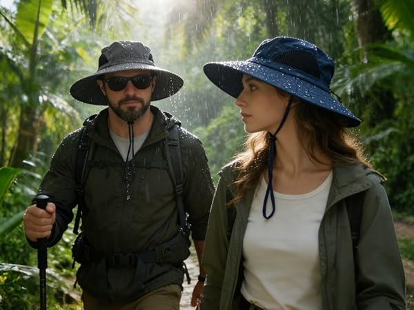 Couple in waterproof sun hats hike in a rainy jungle. Durable safari hat for wet outdoor trips.