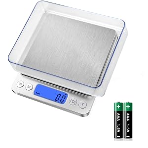 Digital kitchen scale with stainless steel platform, blue backlit LCD display, and control buttons. Includes two AA batteries. Features a removable weighing tray with blue trim.