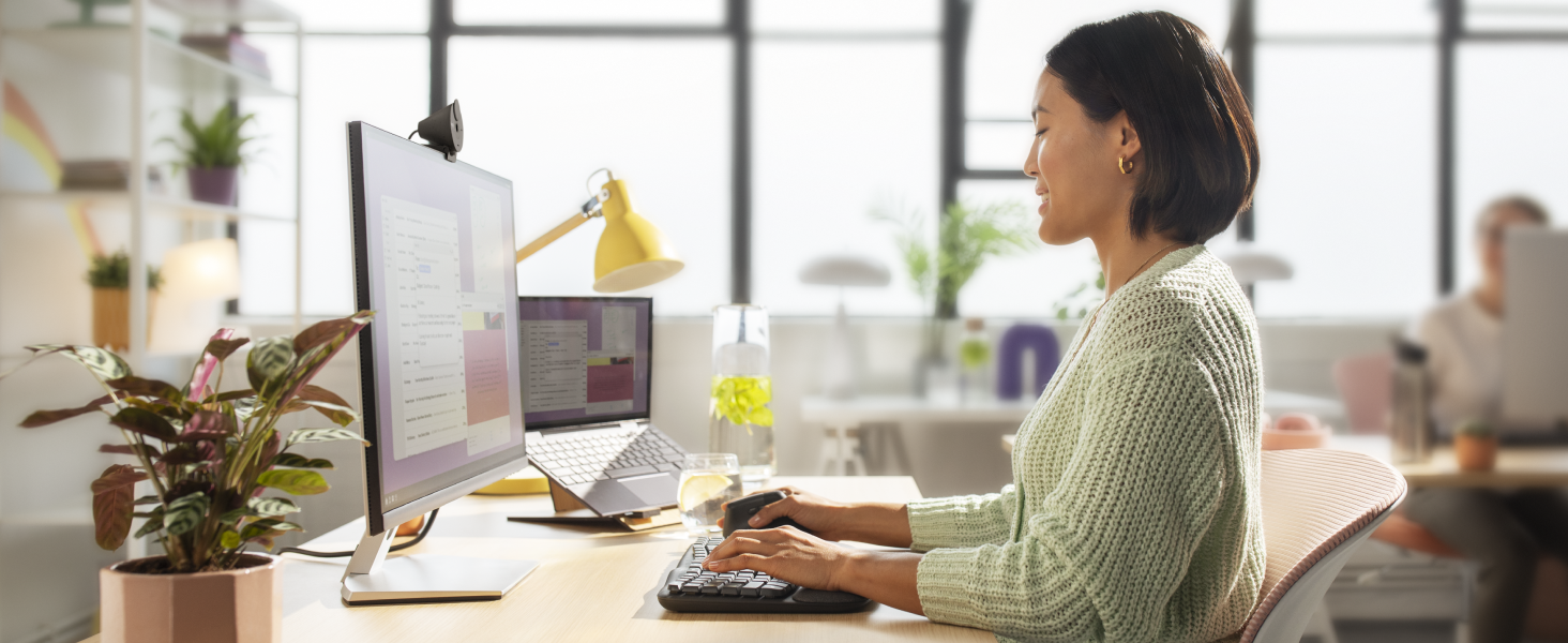a woman typing on wave keys for business wireless ergonomic compact keyboard