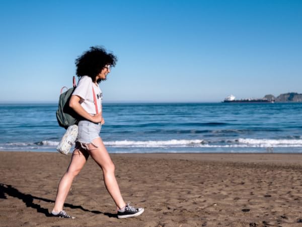 Mobile A Girl is walking on the beach with Turkish Towel