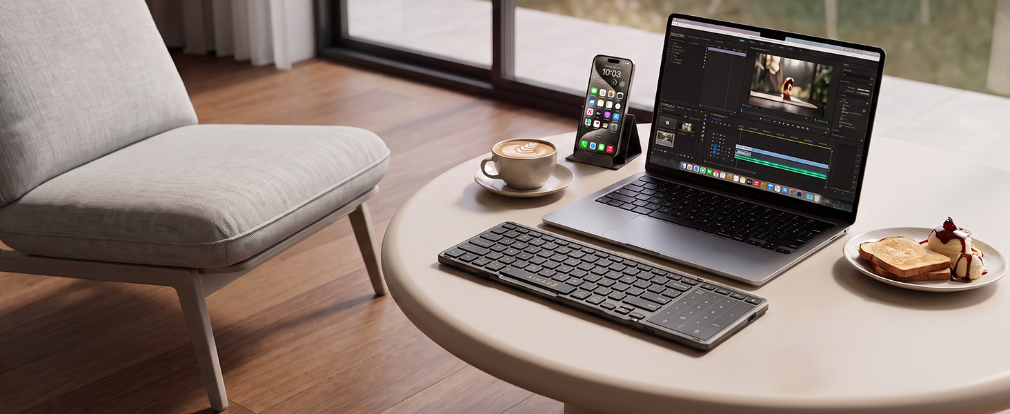Aimarz AF01 keyboard paired with a laptop and phone in a relaxed mobile workspace.