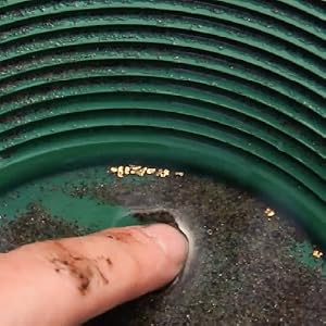 image showing close up of gold flakes caught in gold pan
