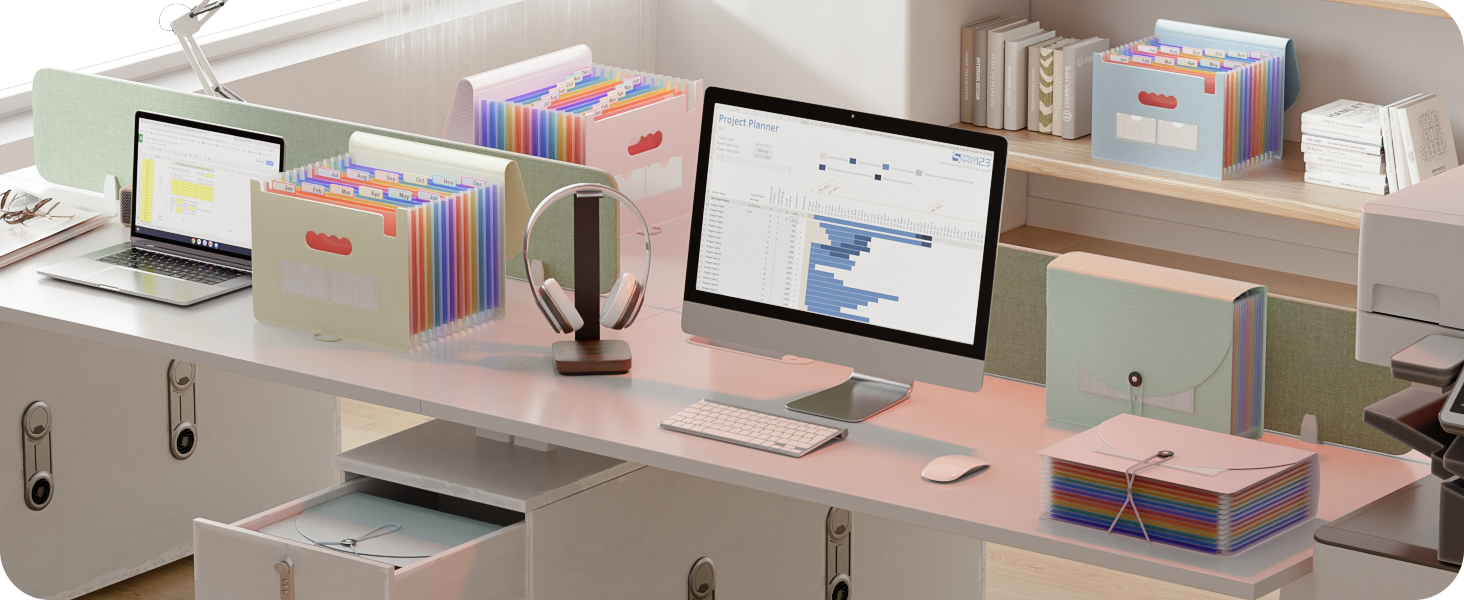 Modern office workspace setup with multiple monitors, laptops, and organized filing systems with colorful folders on desk.