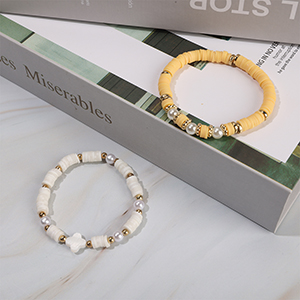 Two bracelets made of solid colors clay heshi beads are on the table.