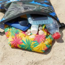 Waterproof dry bag with beach items towel sunscreen bottle and travel gear
