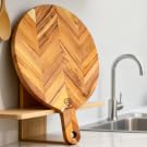 Natural wood cutting boards, serving tray, salad bowls displayed as kitchen essentials