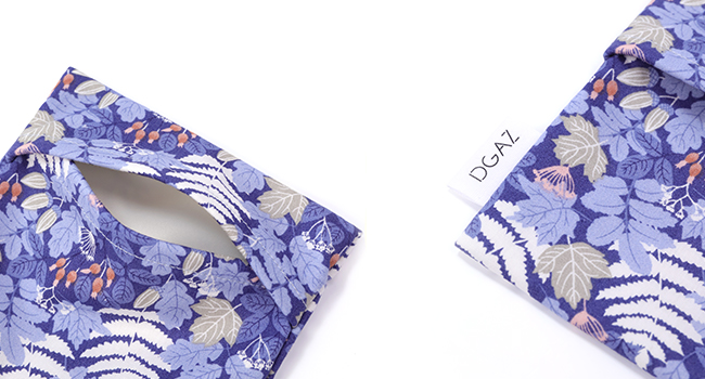 A soft pink silk or satin headband with floral pattern trim displayed against white background.