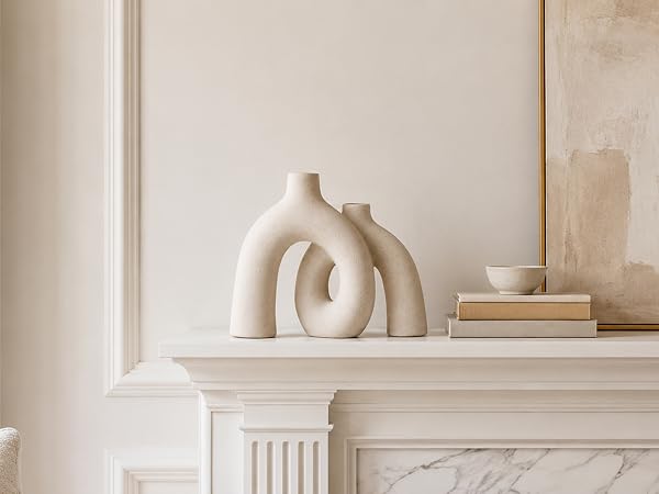 Cream ceramic donut vase displayed on a white fireplace mantel with neutral wall art