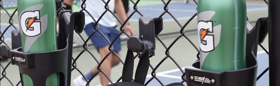 Fence Buddy hook and cup holders mounted on a chain link fence at a pickleball court with players