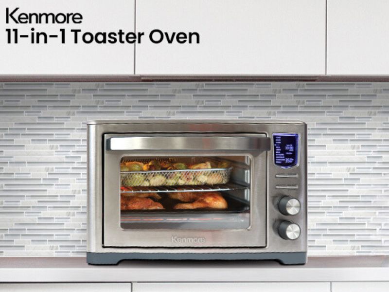 Kenmore digital toaster oven air fryer rotisserie on a kitchen counter with food cooking inside.