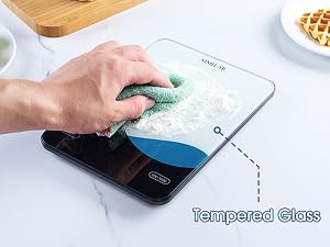 Text reads 'Tempered Glass'. Shows hand cleaning a glass surface with blue tint and measuring scale, next to what appears to be food items.