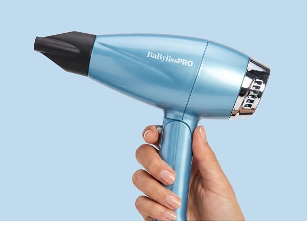 A hand holds the blue dryer with nozzle, highlighting folding, dual-voltage travel use.