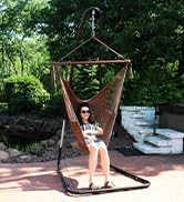 woman sitting in brown caribbean XL hanging hammock chair in a backyard with a patio and pond
