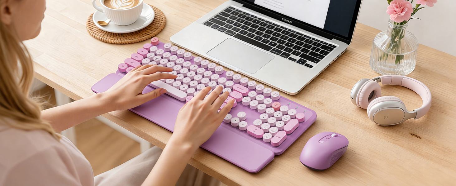 Person using a lavender purple round-keycap wireless keyboard with wrist rest and matching mouse