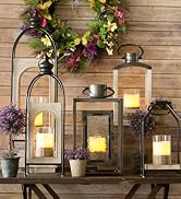 A selection of bright candle lanterns sit on an indoor table creating a warm atmosphere