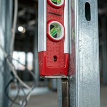 Close-up of magnetic strip holding level to metal stud