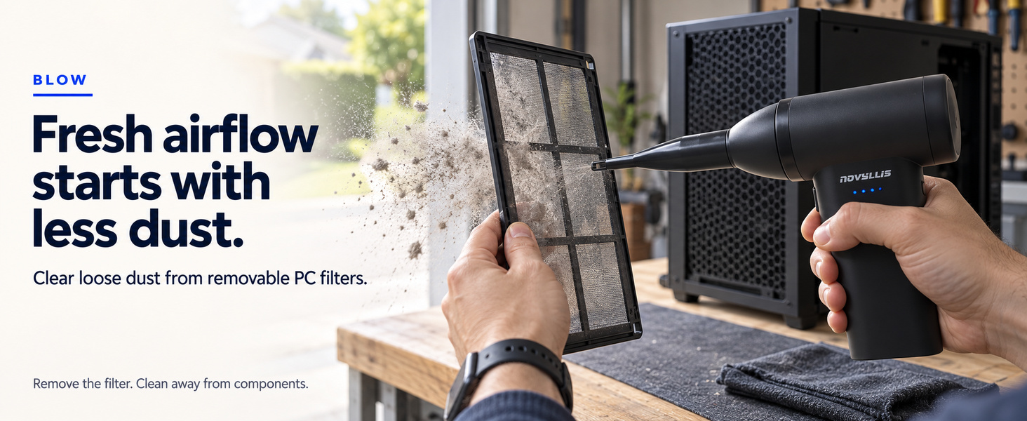 Cordless air duster blowing loose dust off a removable PC dust filter outside the computer case