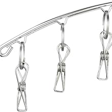 Close-up of a stainless steel rod with multiple hanging clips attached. The clips appear to be for holding items on a line or rail.