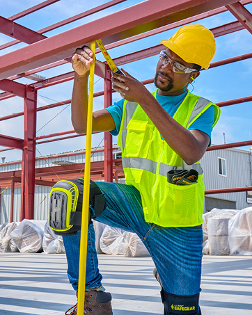 Construction worker with hard hat, knee pads, hi vis vest
