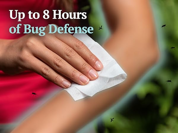 Person wiping arm with Wild Guard Mosquito Repellent Wipe while mosquitoes fly nearby outdoors.