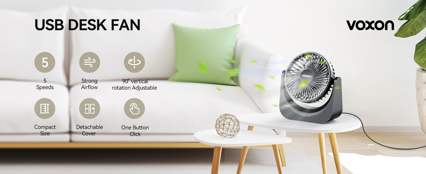 Voxon USB desk fan with adjustable speed and direction. Gray circular fan on white table, product features displayed as icons. Green cushions in background.