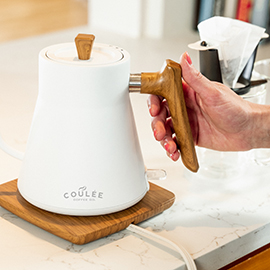 Woman's hand on wood ergonomic kettle handle