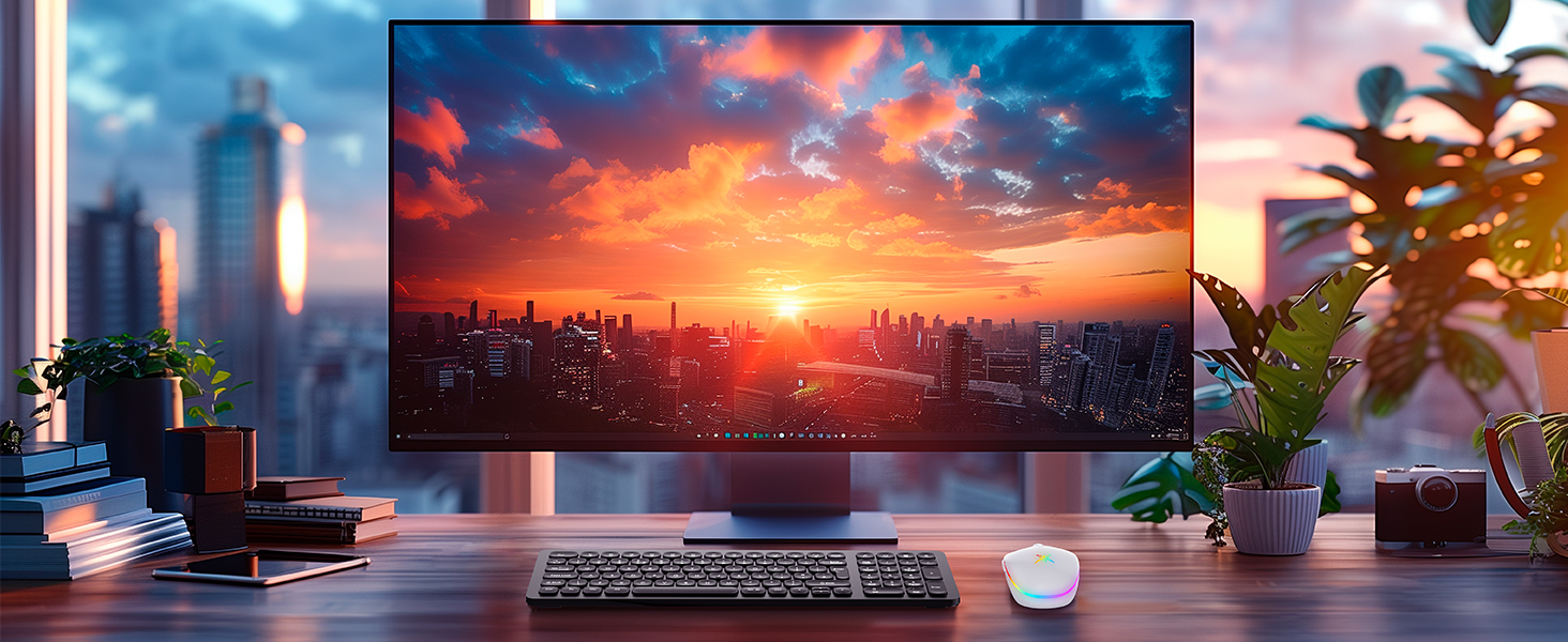 Widescreen monitor displaying vibrant cityscape sunset, positioned on desk with keyboard, mouse, plants, and books, showcasing high-quality display capabilities.