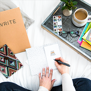 sitting on a bed writing inside a card