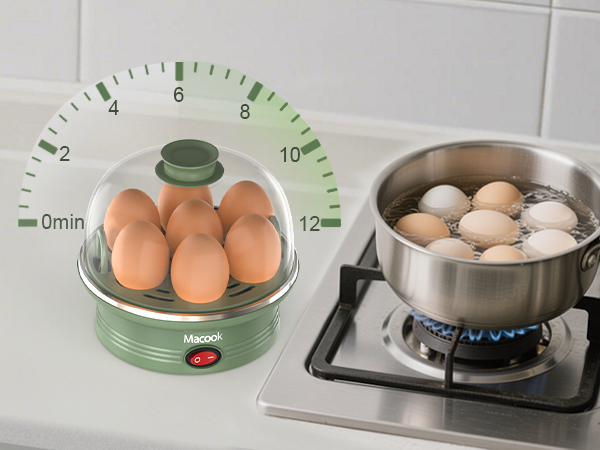 Green egg cooker with timer dial holding brown eggs next to stainless steel pot on gas stove boiling eggs. Macook brand visible on cooker.
