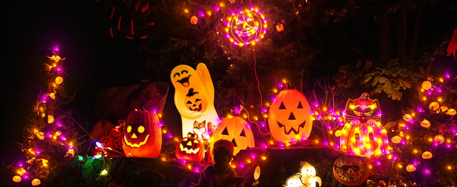 Nighttime scene with illuminated Jack-o'-lantern pumpkins and colorful string lights, creating a festive Halloween display.
