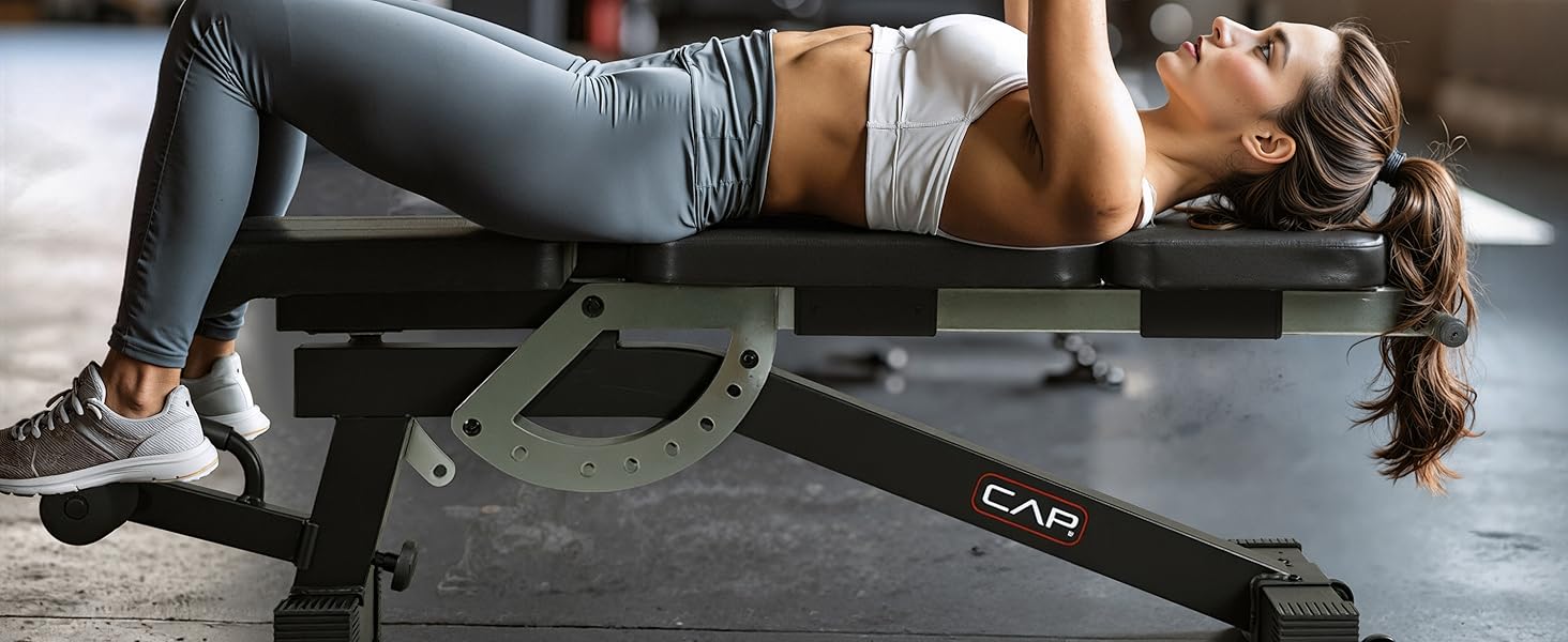 woman doing bench press on CAP Barbell weight bench in home gym