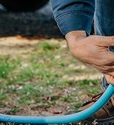 Camper hooking up their freshwater system with the Camco Tastepure rv water filter and hose