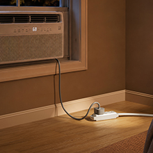 Maximm heavy duty flat extension cord powering a window air conditioner unit seamlessly.