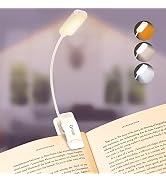 Flexible USB book light with three brightness settings shown clipped to a book page. White LED light on gooseneck arm with clip-on base.