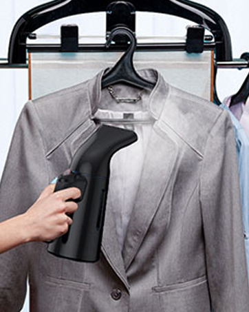 a woman using a spray bottle to clean clothes