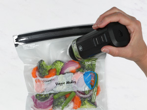 Vacuum-sealed bag with vegetables and hand holding device