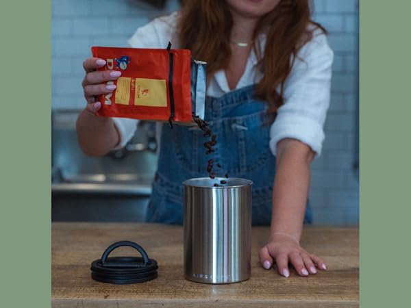 pouring beans into a brushed steel airscape canister