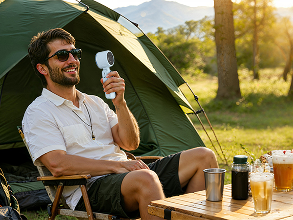 Man camping with blue rechargeable fan outdoors powerful small fan for hot summer days tent