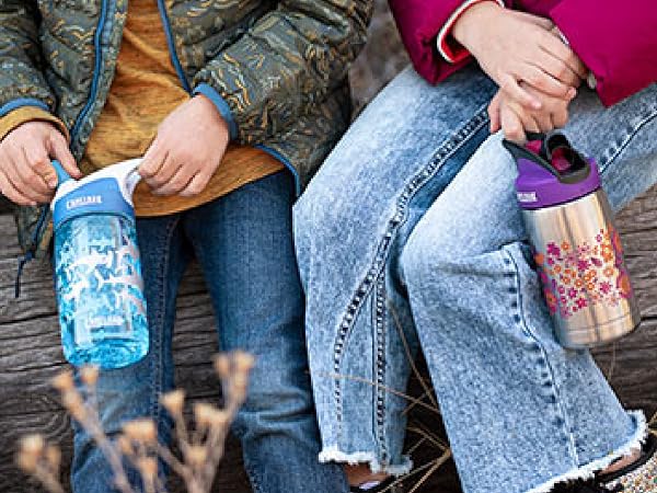 Three kids holding thrive kids water bottles