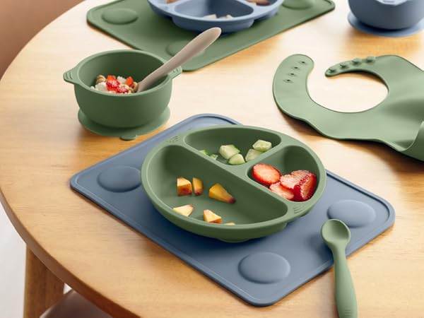 Prep silicone placemats with divided plate, bowl, spoon, and baby feeding accessories on table setup
