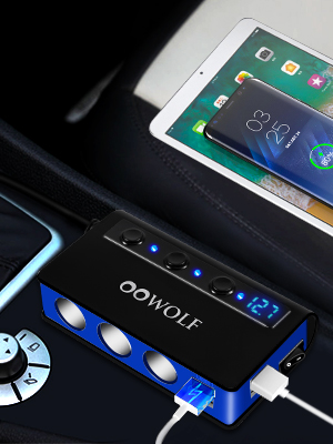 Black electronic device with LED display and multiple USB ports. Shown charging tablets and smartphone simultaneously.